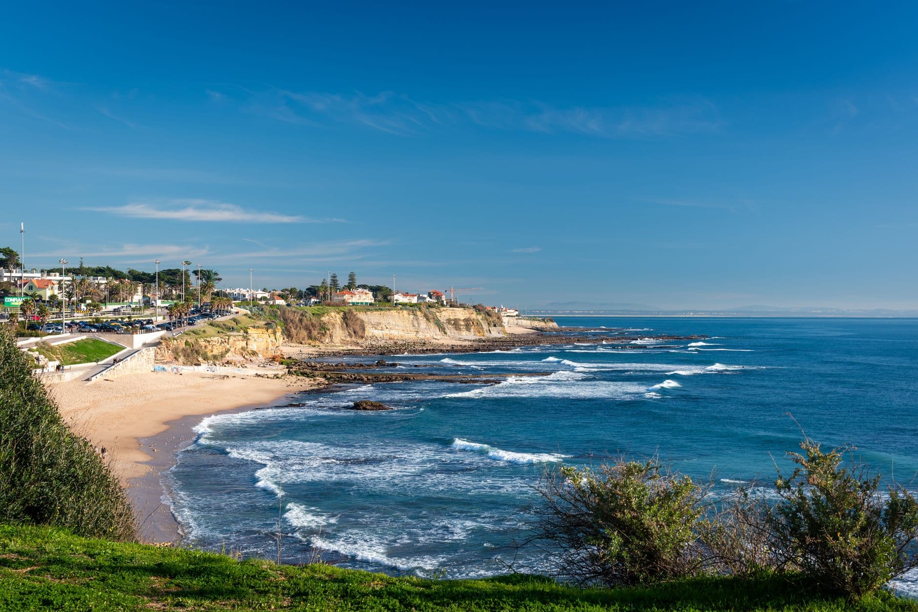 Beautiful coastal view of a sandy beach with cliffs in Lisbon, Portugal.