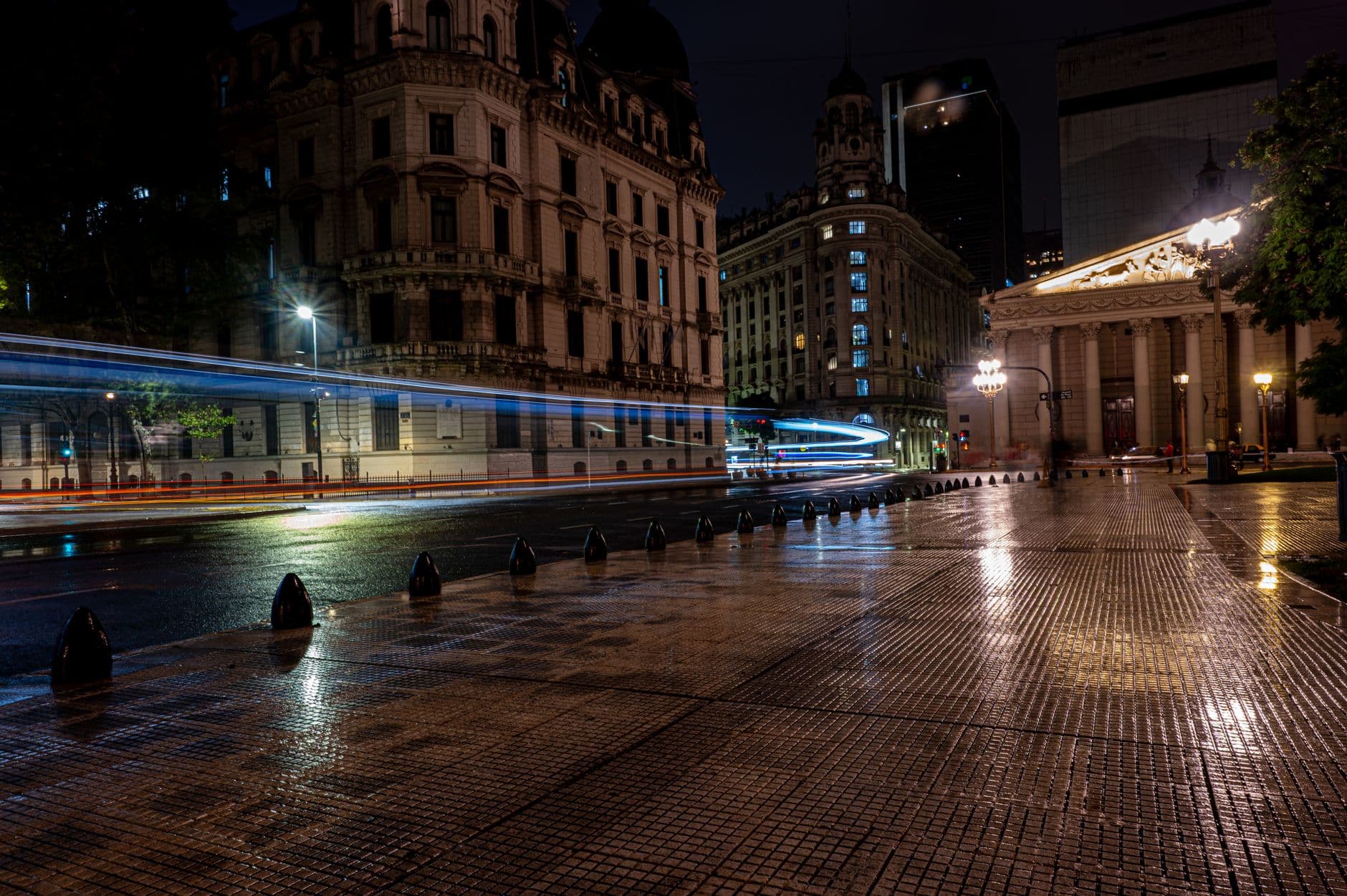 Vibrant nighttime cityscape of Buenos Aires featuring blurred traffic lights and historic architecture.