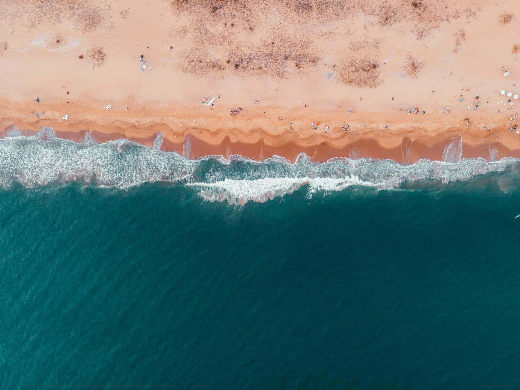 Stunning aerial view of Punta del Este beach with crashing waves and golden sand in Uruguay.