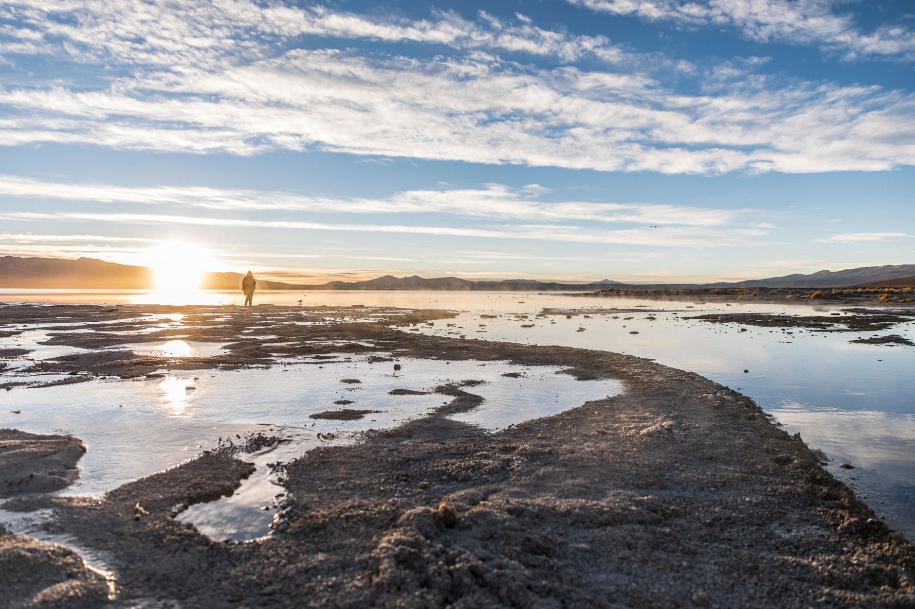 Peaceful sunrise at Antofagasta beach with soft reflections and distant person.