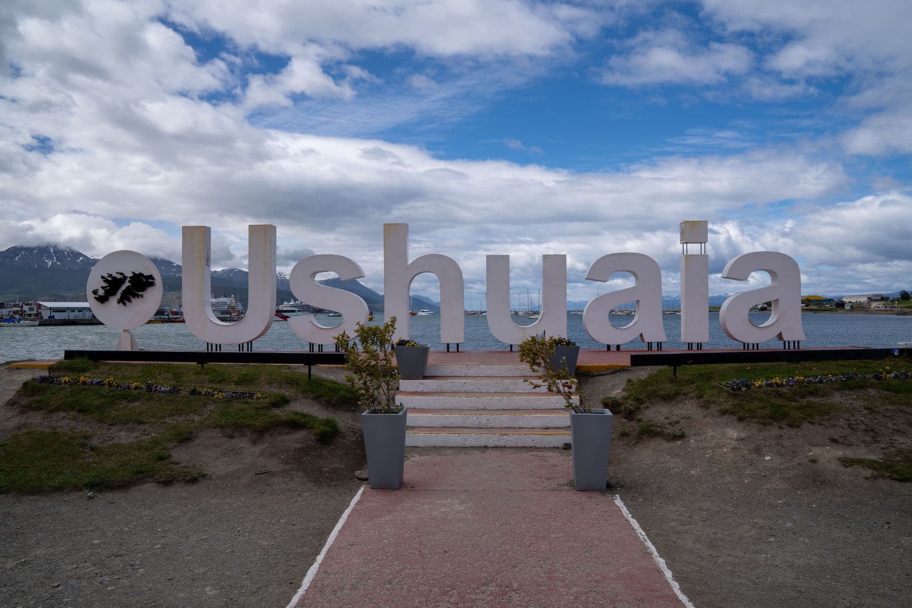 Iconic Ushuaia sign in Argentina with stunning mountain and sea view.