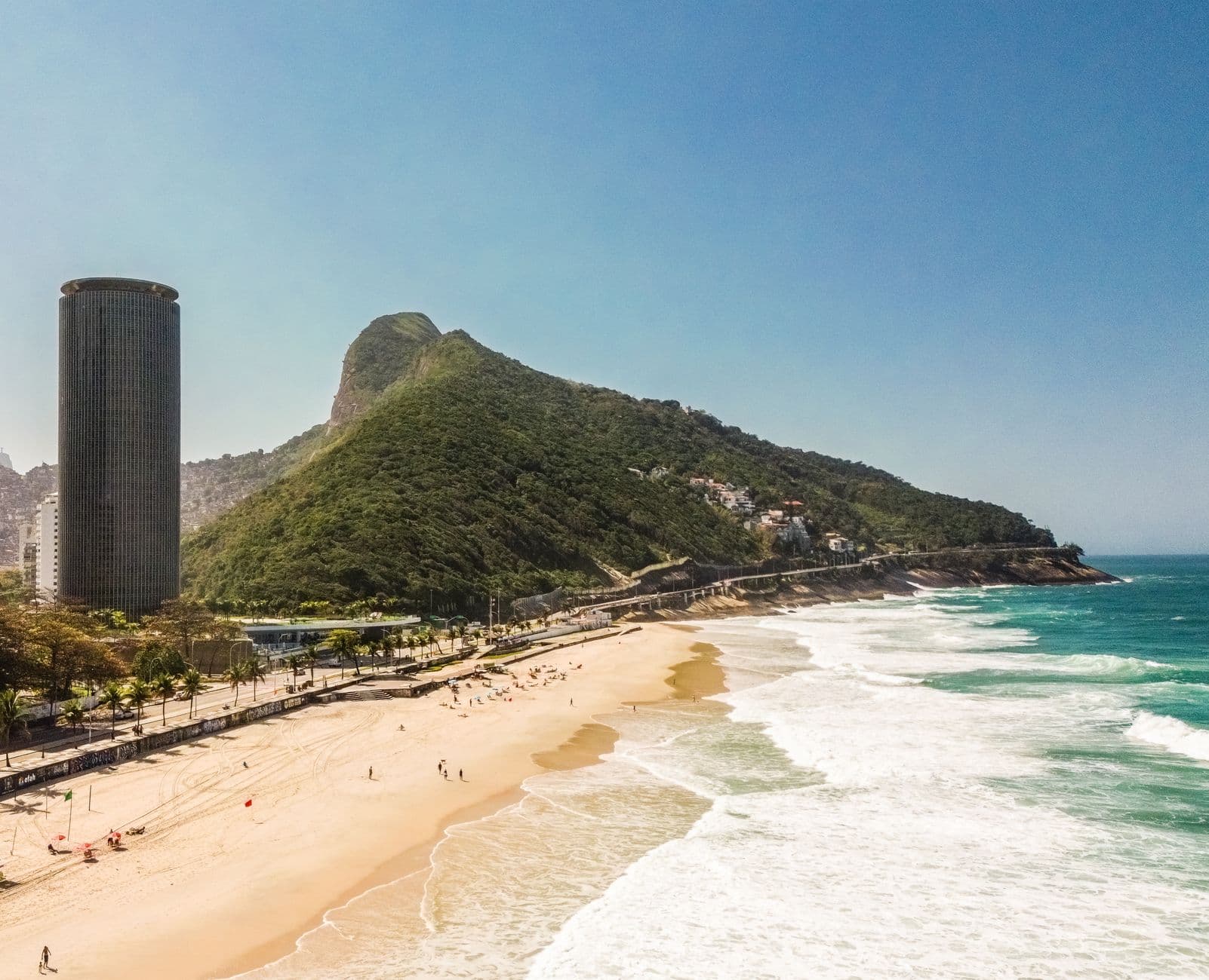 Breathtaking view of Rio's coastline with a beach, skyscraper, and mountain.