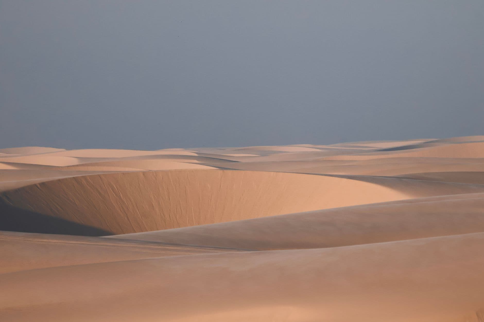 Capture the serene beauty of Lençóis Maranhenses' sands during sunrise, Maranhão, Brazil.