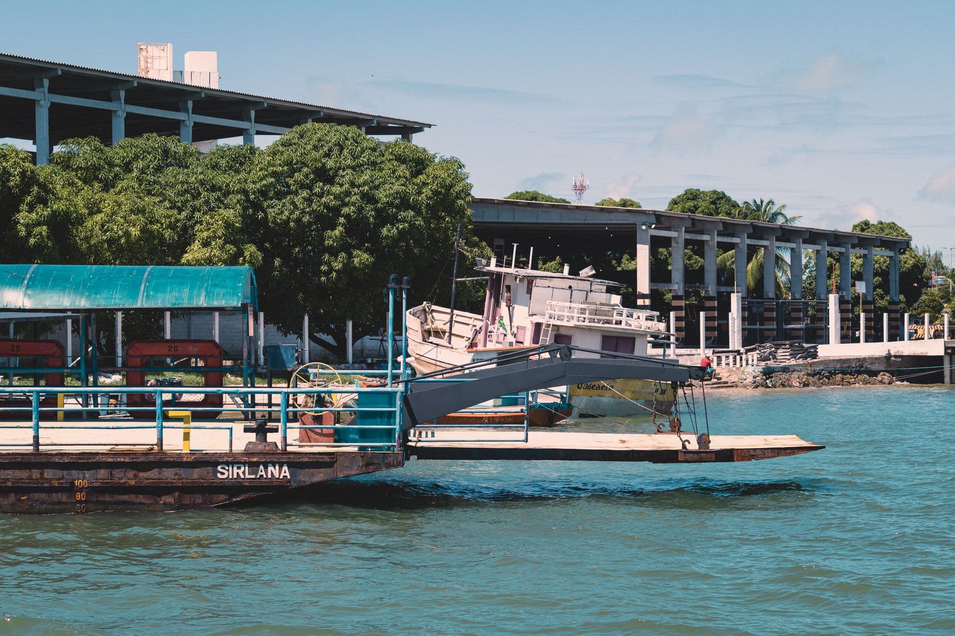 View of boats docked at João Pessoa harbor under a clear sky, showcasing the coastal vibe.