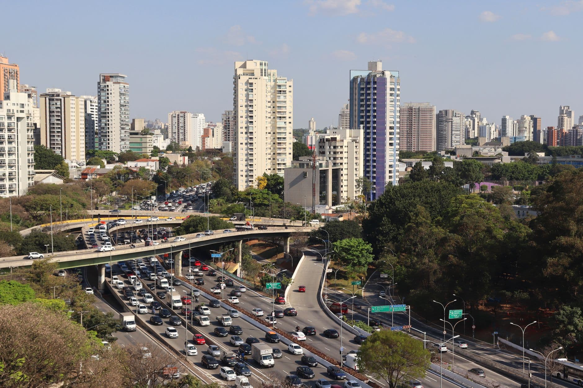 Aerial view of a bustling expressway and urban skyline in São Paulo, Brazil.
