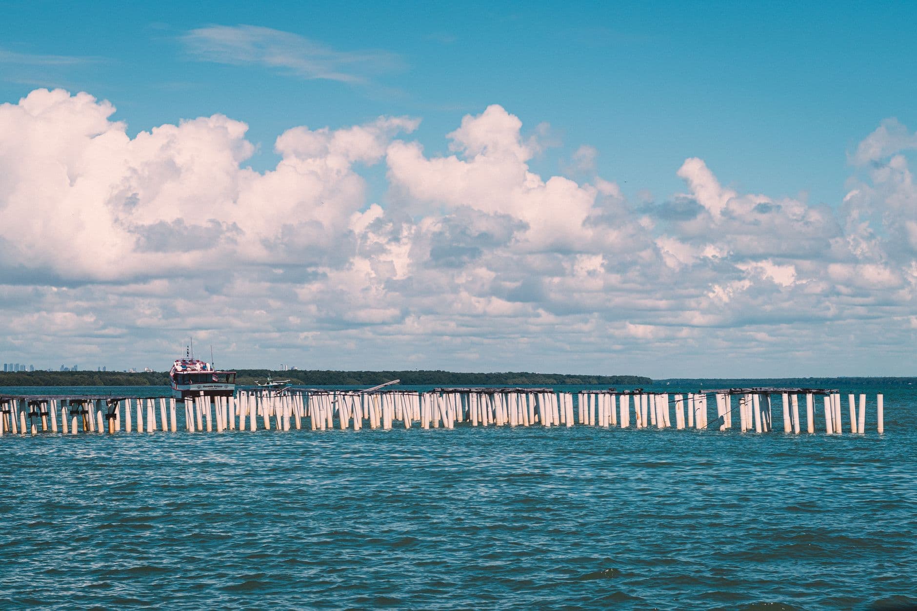 A scenic ocean view with a pier and cloudy sky at João Pessoa, Brazil.