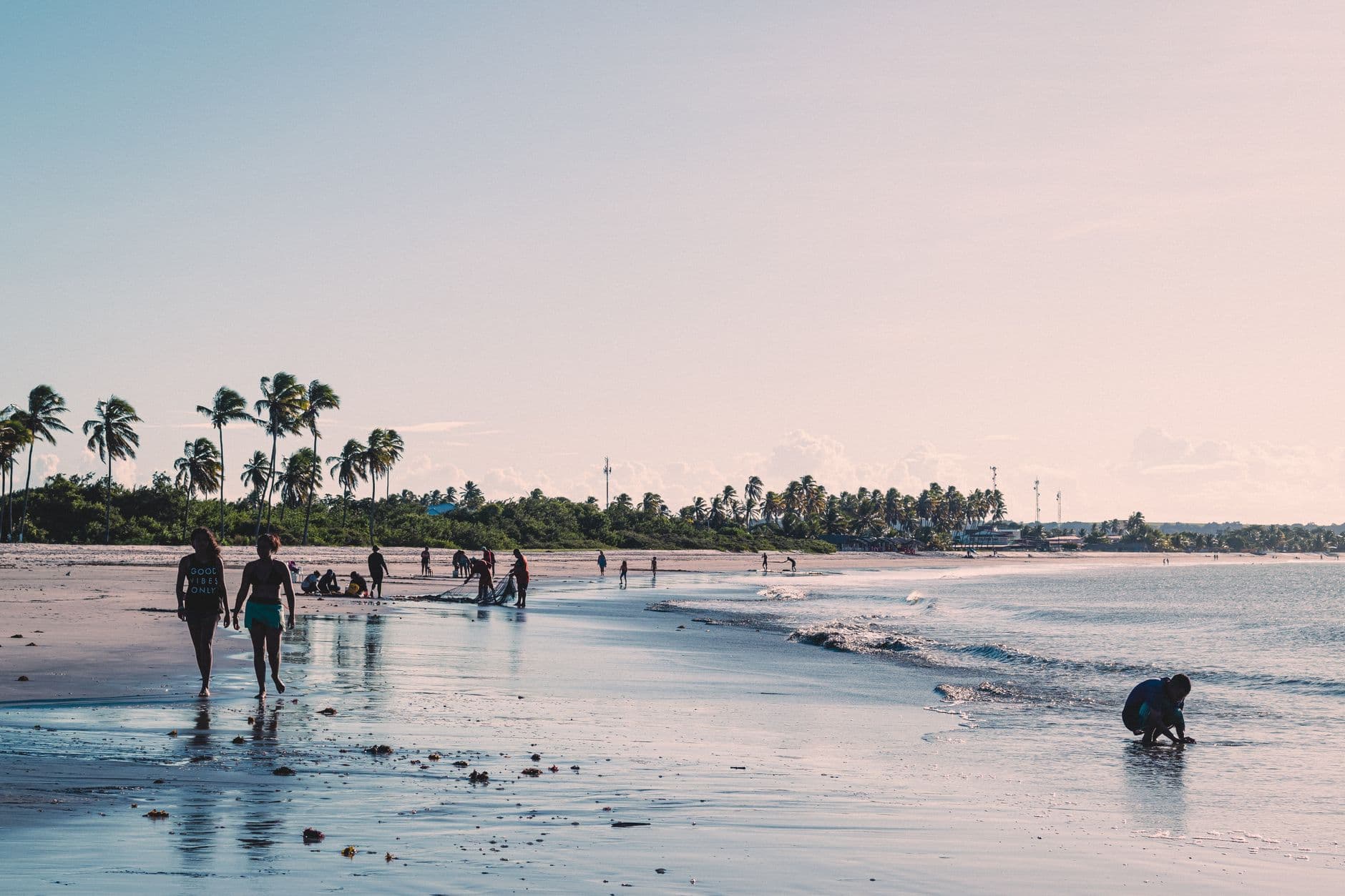 A serene beach in João Pessoa with people enjoying the sun and sea on a warm day.