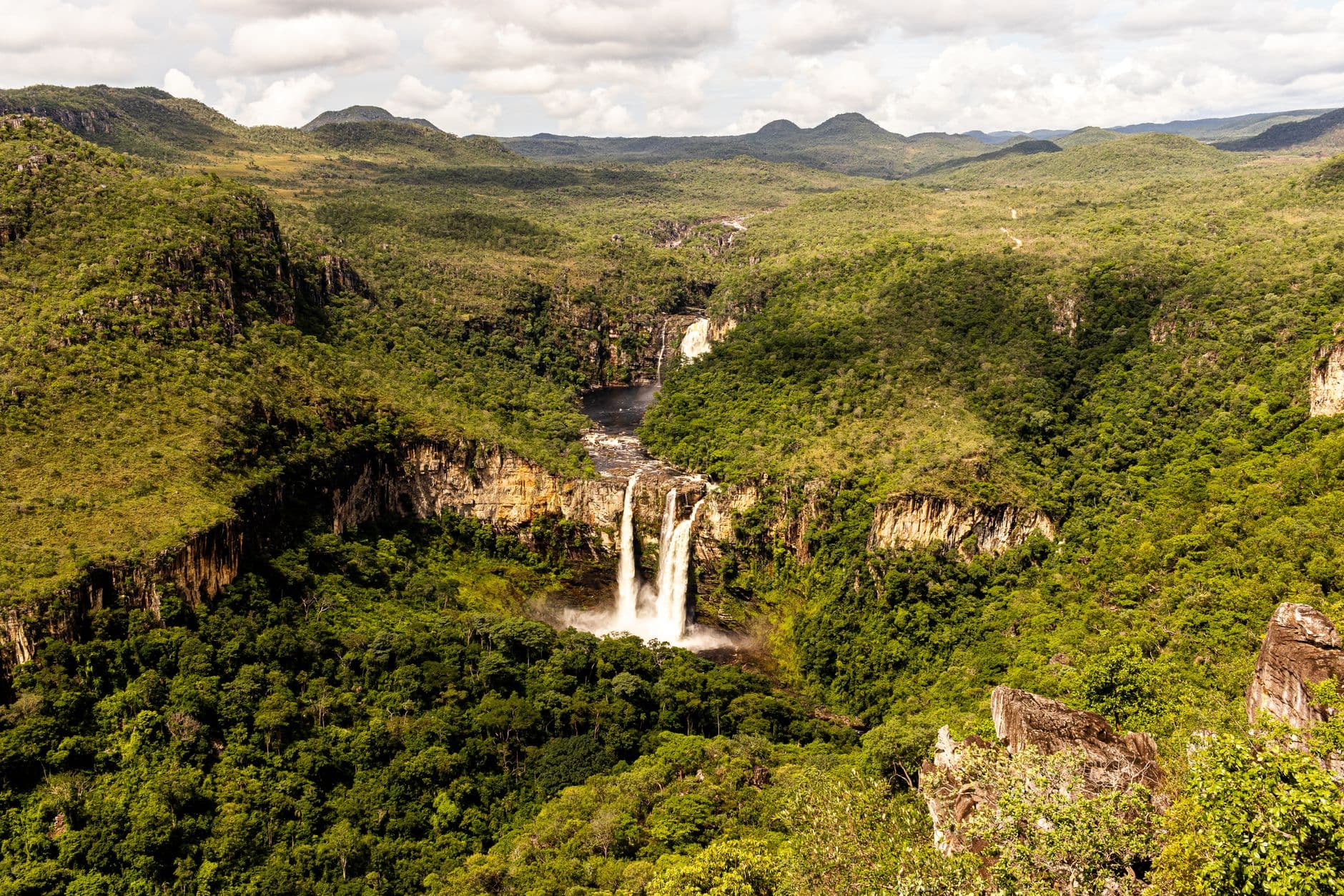 A breathtaking aerial view of a waterfall amidst lush greenery in Brazil's national park.