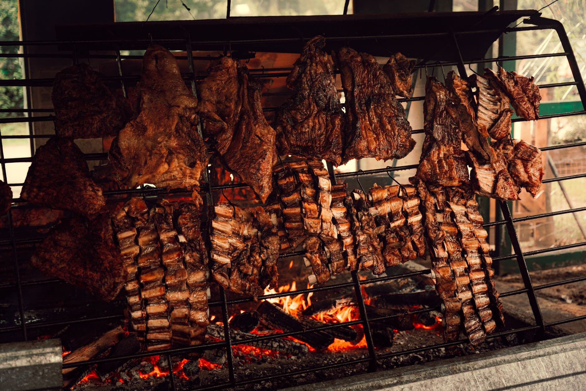 Authentic Argentine asado grilling beef ribs over open flames in Uribelarrea.