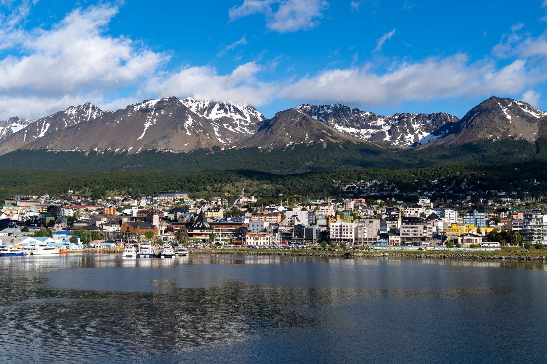 Discover the stunning cityscape of Ushuaia, Argentina with snow-capped mountains as a backdrop.