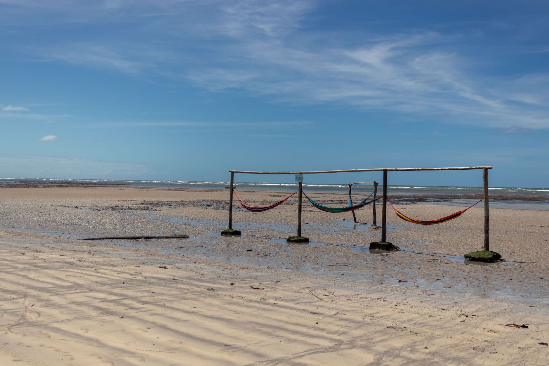 Vibrant hammocks on a serene beach in Morro de São Paulo, Bahia, Brazil.
